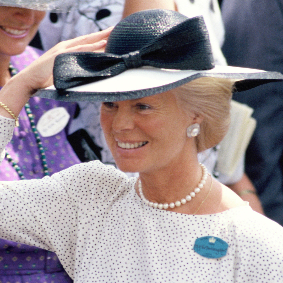 The Duchess of Kent wearing a white dress and black hat smiling